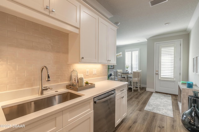 kitchen with tasteful backsplash, sink, white cabinets, and stainless steel dishwasher