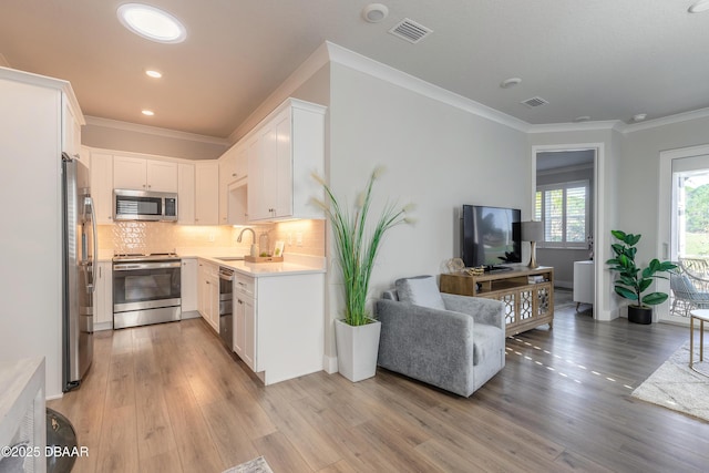 kitchen featuring backsplash, white cabinetry, sink, and stainless steel appliances