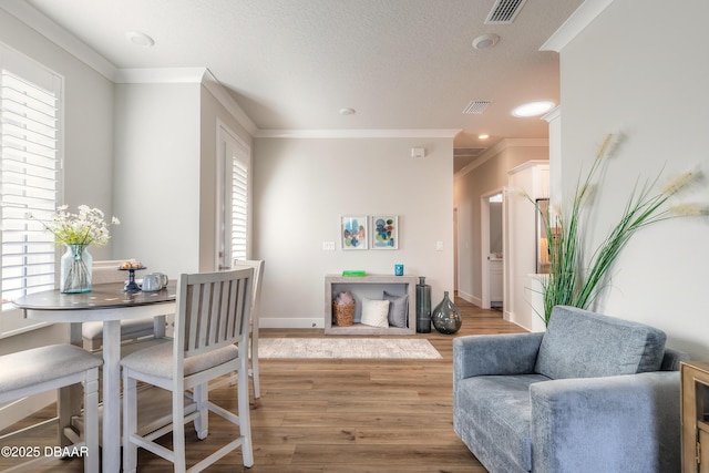 dining space featuring hardwood / wood-style flooring and crown molding