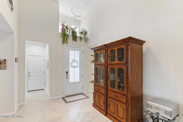 tiled foyer featuring a high ceiling and a chandelier