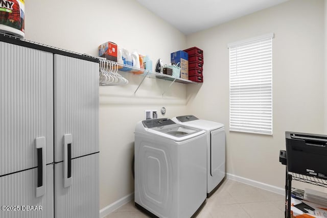 laundry area with light tile patterned floors and washing machine and clothes dryer