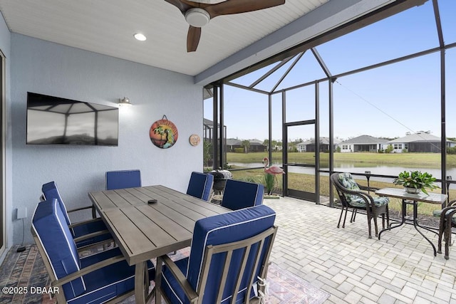 view of patio / terrace featuring a water view, ceiling fan, and a lanai