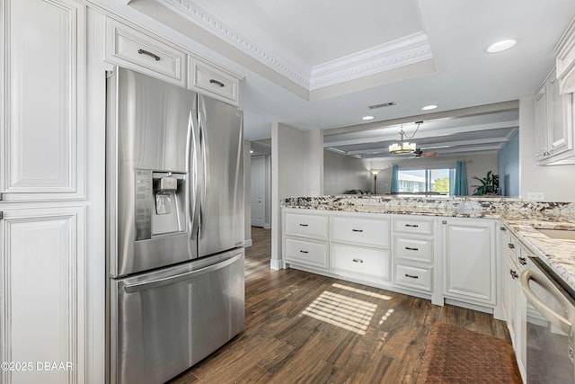 kitchen featuring kitchen peninsula, stainless steel appliances, a tray ceiling, ornamental molding, and white cabinets