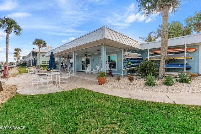 back of property with ceiling fan, a patio area, and a yard