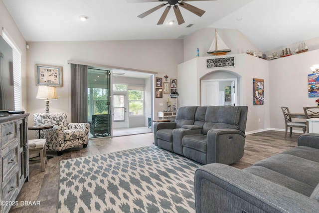 living area featuring a ceiling fan, lofted ceiling, arched walkways, and wood finished floors