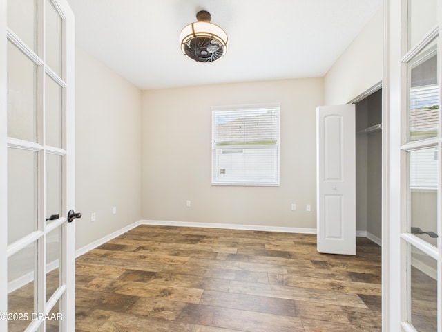 63 Park Place Cir, Palm Coast, FL 32164 - unfurnished bedroom with french doors, dark wood-style floors, multiple windows, and baseboards