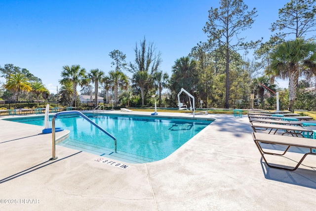 community pool with fence and a patio