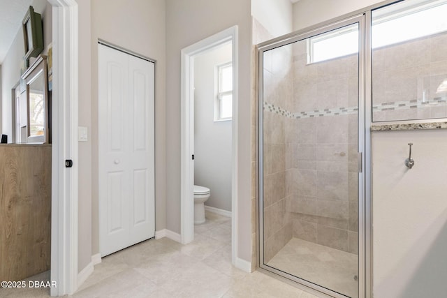 full bathroom with toilet, a stall shower, baseboards, and a wealth of natural light