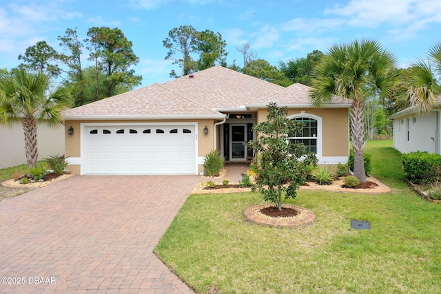 ranch-style home featuring decorative driveway, roof with shingles, stucco siding, an attached garage, and a front yard