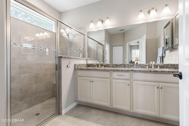 full bath with tile patterned flooring, a sink, a shower stall, and double vanity