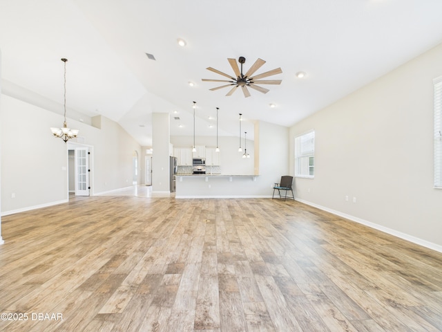 63 Park Place Cir, Palm Coast, FL 32164 - unfurnished living room featuring vaulted ceiling, a chandelier, light wood-style flooring, baseboards, and recessed lighting
