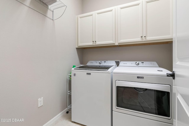 laundry room with cabinet space, baseboards, and separate washer and dryer