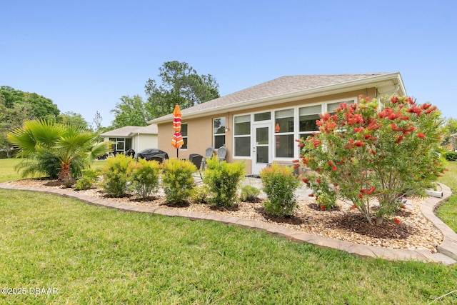 exterior space with a front lawn and stucco siding