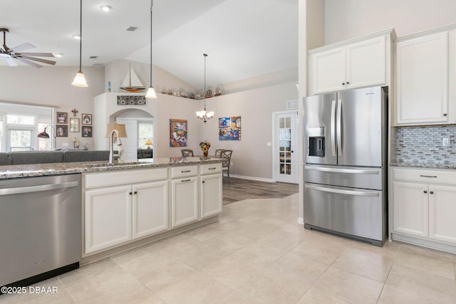 kitchen with appliances with stainless steel finishes, a sink, a wealth of natural light, and decorative backsplash