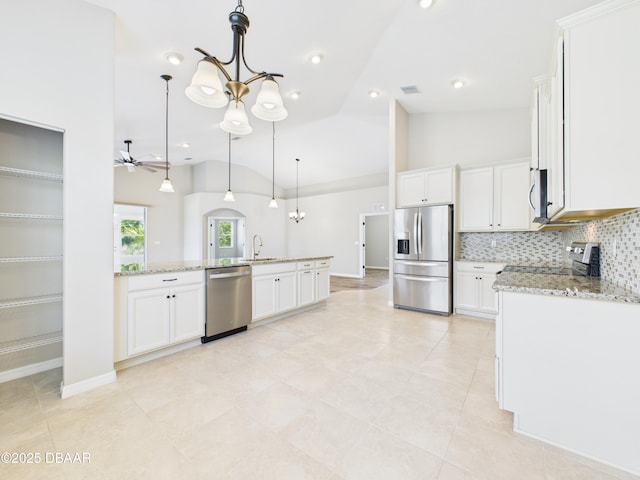 63 Park Place Cir, Palm Coast, FL 32164 - kitchen with appliances with stainless steel finishes, a sink, vaulted ceiling, ceiling fan, and white cabinetry