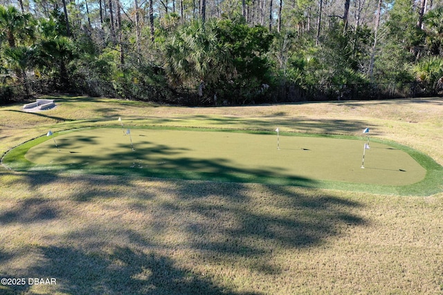 view of property's community featuring a lawn and fence