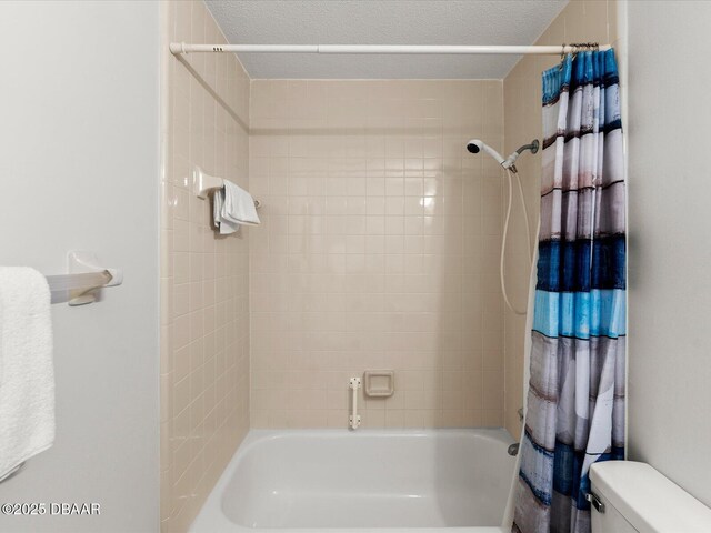 bathroom featuring toilet, shower / bath combo with shower curtain, and a textured ceiling