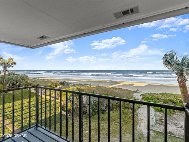 balcony featuring a view of the beach and a water view