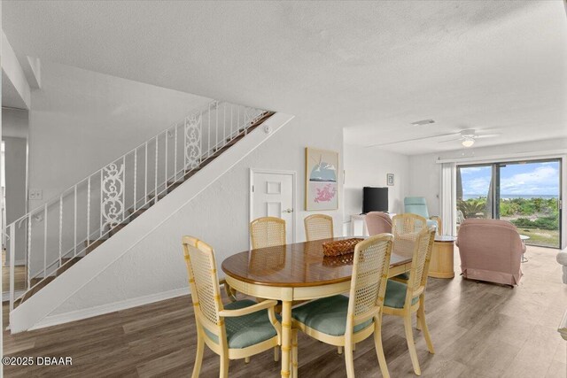 dining area featuring dark hardwood / wood-style flooring, ceiling fan, and a textured ceiling