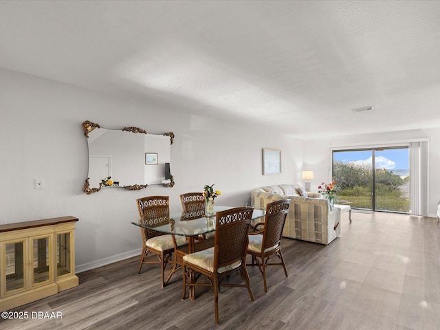 dining room with hardwood / wood-style floors and a textured ceiling