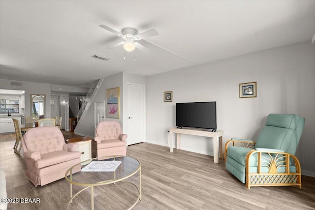 living room featuring ceiling fan and light hardwood / wood-style floors