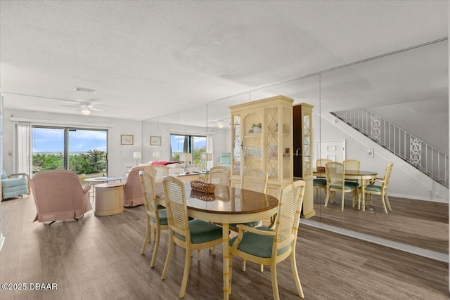 dining area featuring ceiling fan, hardwood / wood-style floors, and a textured ceiling