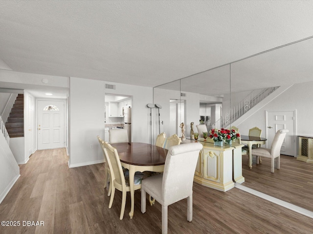 dining area with hardwood / wood-style floors and a textured ceiling