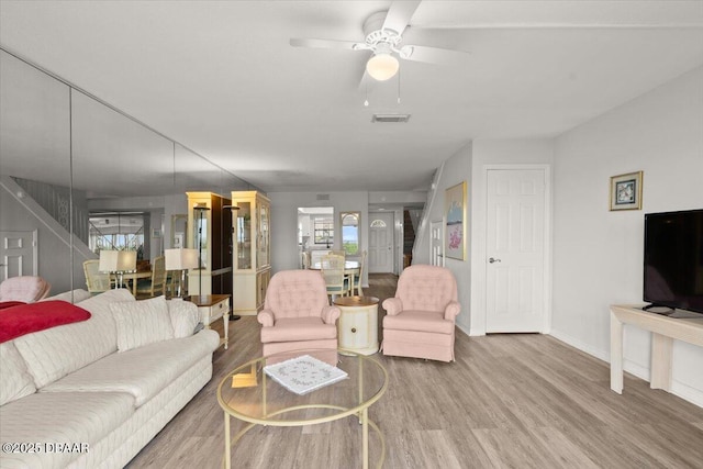 living room featuring hardwood / wood-style floors and ceiling fan