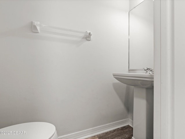 bathroom with wood-type flooring, sink, and toilet