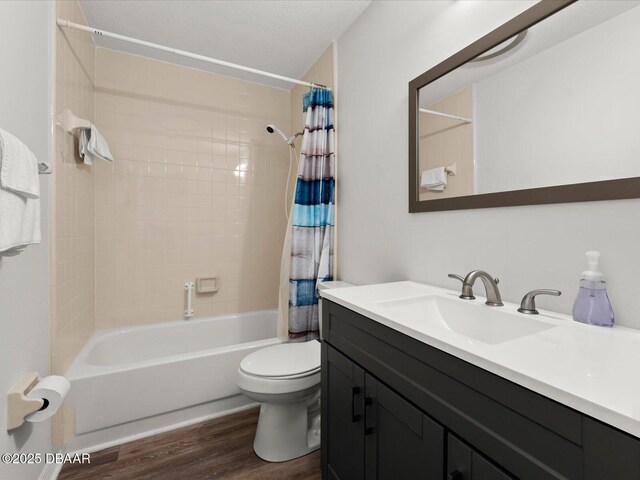 full bathroom featuring shower / bath combo, vanity, wood-type flooring, a textured ceiling, and toilet