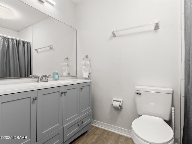 bathroom featuring walk in shower, wood-type flooring, toilet, and vanity