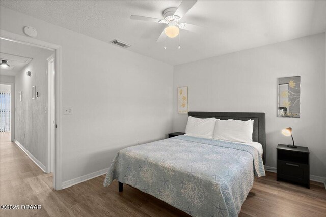 bedroom with ceiling fan and wood-type flooring