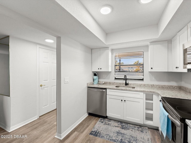 kitchen with sink, a raised ceiling, stainless steel appliances, hardwood / wood-style floors, and white cabinets