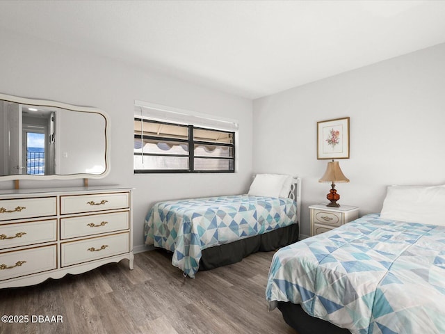 bedroom with multiple windows and hardwood / wood-style floors