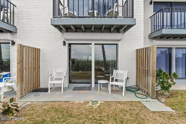 entrance to property featuring a balcony and a patio area