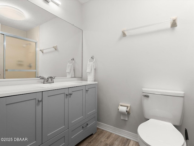 bathroom featuring vanity, hardwood / wood-style floors, toilet, and an enclosed shower