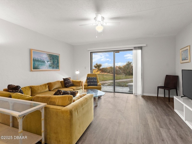 living room featuring ceiling fan, hardwood / wood-style floors, and a textured ceiling