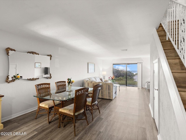 dining area with hardwood / wood-style floors and a textured ceiling