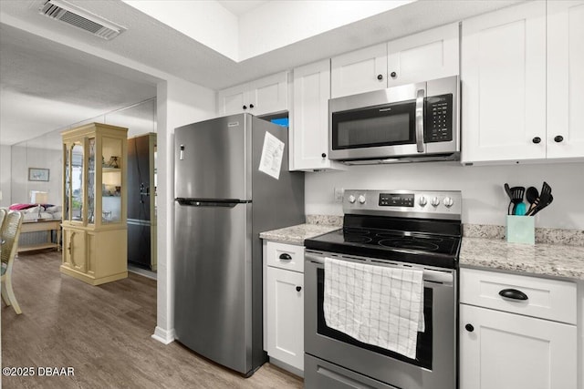 kitchen featuring stainless steel appliances, white cabinetry, and wood-type flooring