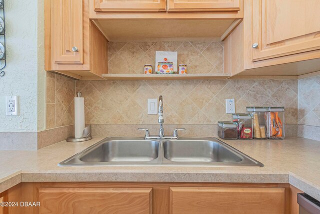 kitchen with light brown cabinets, sink, dishwasher, and backsplash