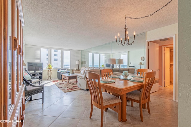 tiled dining area featuring a textured ceiling and a chandelier