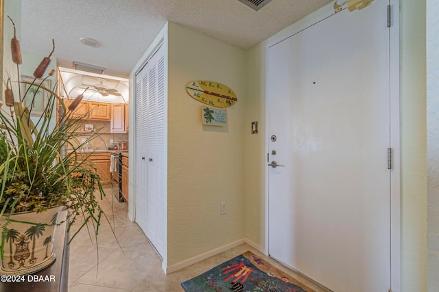 tiled entrance foyer with a textured ceiling