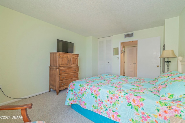 carpeted bedroom with a textured ceiling and a closet