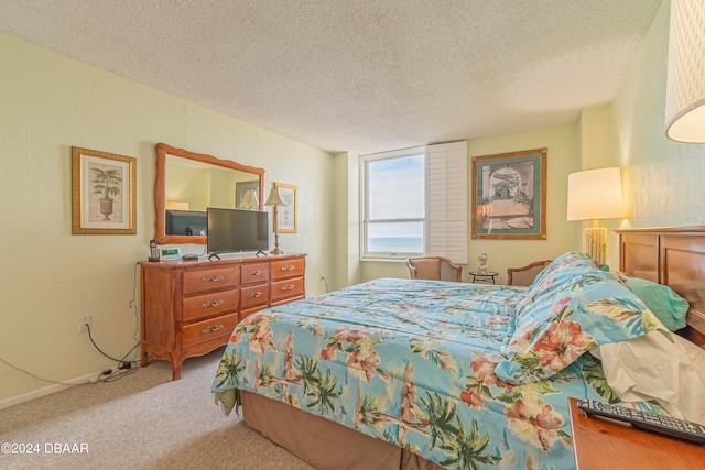 bedroom with light colored carpet and a textured ceiling