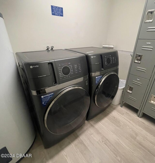 laundry room featuring separate washer and dryer and light hardwood / wood-style floors