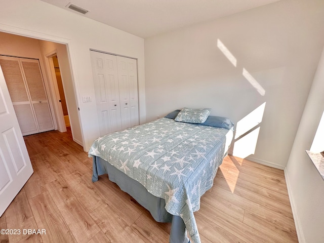 bedroom with light hardwood / wood-style floors and a closet