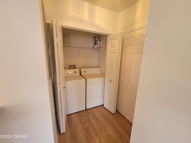 laundry room featuring separate washer and dryer and light hardwood / wood-style flooring