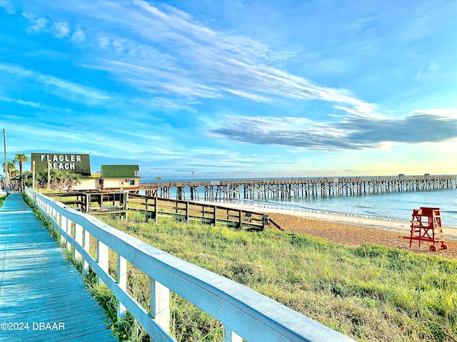 dock area with a water view and a beach view