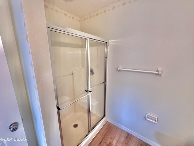 bathroom featuring a shower with door and hardwood / wood-style floors