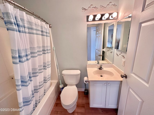 full bathroom with hardwood / wood-style flooring, shower / tub combo with curtain, vanity, and toilet